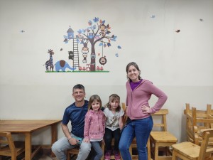 Foto de Jorge, Mónica, Vera y Salma ante un mural en el Hogar